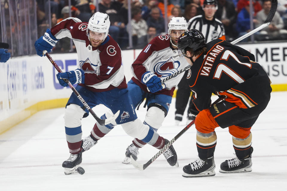 Colorado Avalanche defenseman Devon Toews (7) and Anaheim Ducks forward Frank Vatrano (77) vie for the puck during the first period of an NHL hockey game in Anaheim, Calif., Monday, March 27, 2023. (AP Photo/Ringo H.W. Chiu)