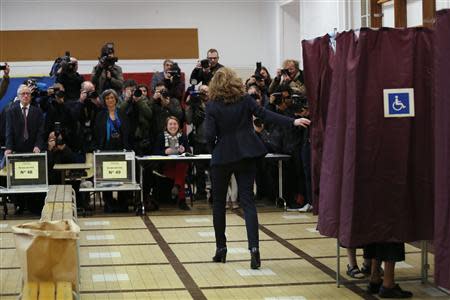 Journalists watch as Nathalie Kosciusko-Morizet (C), conservative UMP political party candidate for the mayoral election, leaves the voting both as she prepares to cast her ballot in Paris, March 30, 2014. The French go to the polls to cast votes Sunday in the second round of 2014 municipal elections to elect city mayors and councillors for a six-year term. REUTERS/Gonzalo Fuentes