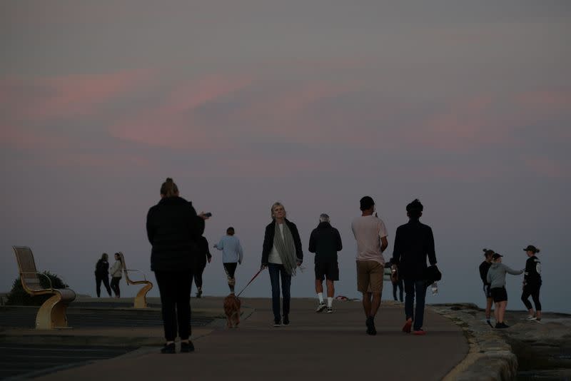 Walkers enjoy sunset at the coast in Sydney