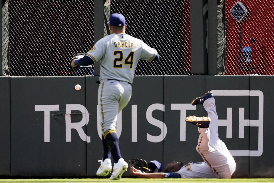 Milwaukee Brewers center fielder Lorenzo Cain (6) loses the ball after colliding with the fence on a hit by Atlanta Braves' Adam Duvall during the fourth inning of Game 3 of a baseball National League Division Series, Monday, Oct. 11, 2021, in Atlanta. (AP Photo/John Bazemore)
