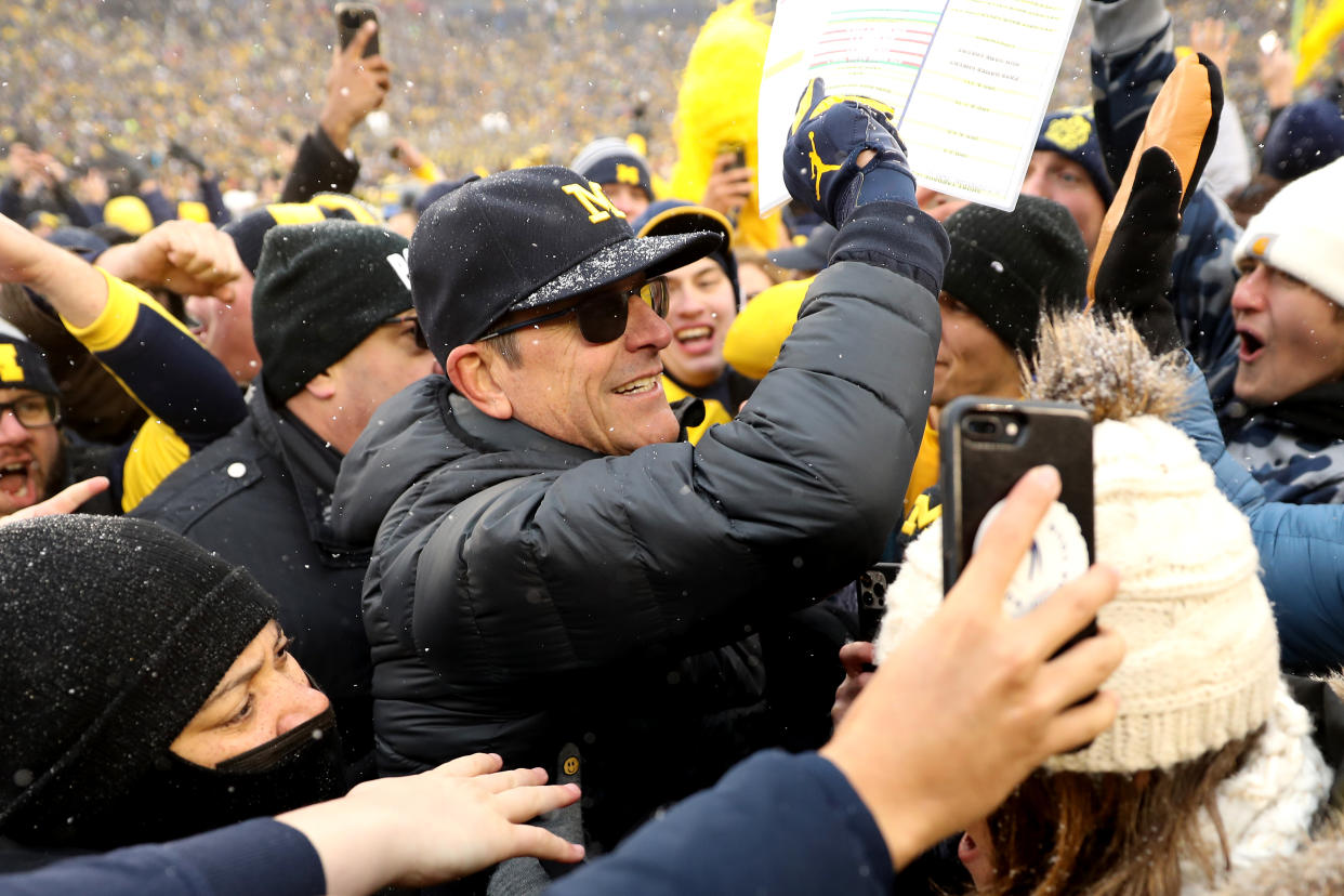 Michigan coach Jim Harbaugh celebrates with fans after defeating the Ohio State Buckeyes at Michigan Stadium on Nov. 27. (Mike Mulholland/Getty Images)