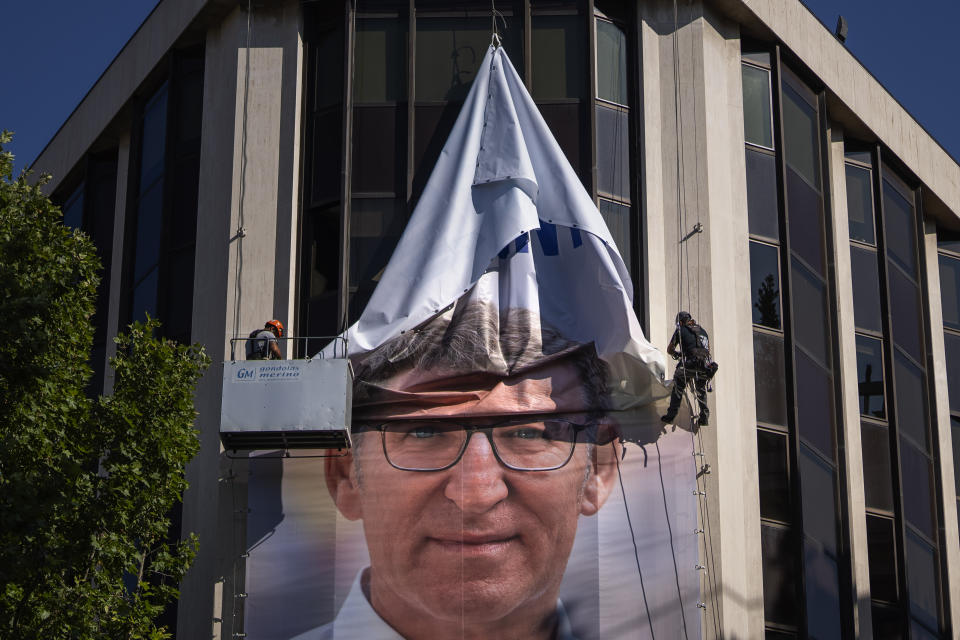 FILE, Workers remove an electoral poster showing Alberto Feijoo, leader of the mainstream conservative Popular Party, at the party headquarters in Madrid, Spain, Monday, July 24, 2023. The leader of Spain’s conservatives will have his opportunity to form a new government this week in what has been preordained as a lost cause given his lack of support in the Parliament. Alberto Núñez Feijóo's Popular Party won the most seats from inconclusive elections in July but fell well short of a majority. (AP Photo/Emilio Morenatti, File)