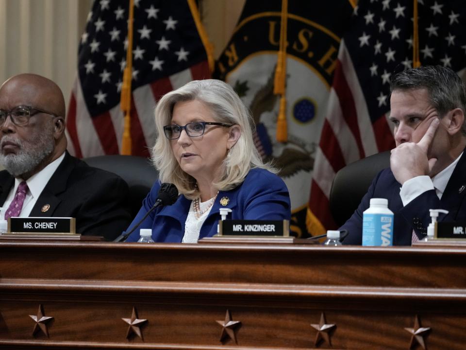 Reps. Liz Cheney, Bennie Thompson, and Adam Kinzinger sit behind a podium.