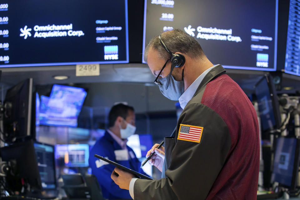 In this photo provided by the New York Stock Exchange, a trader works on the floor during the IPO of Omnichannel Acquisition Corporation, Friday, Nov. 20, 2020. U.S. stocks are pulling a bit lower in midday trading Friday as worries about the worsening pandemic weigh on rising optimism about a coming coronavirus vaccine. (Courtney Crow/New York Stock Exchange via AP)