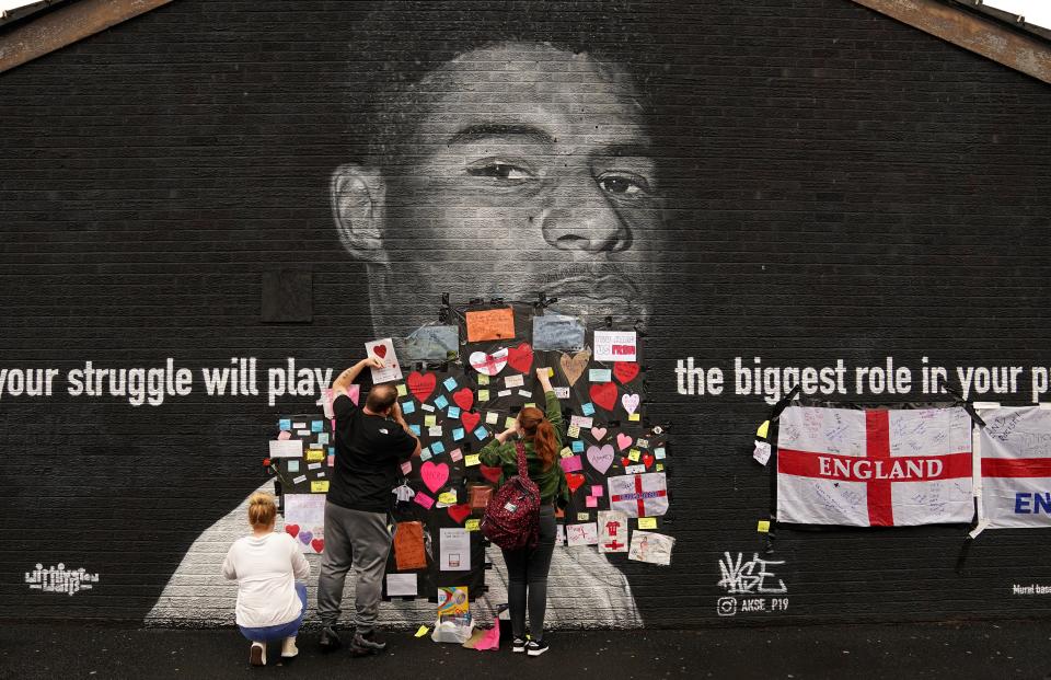 People place messages of support on top of bin liners that were taped over offensive wording on the mural of England forward Marcus Rashford (PA Wire)