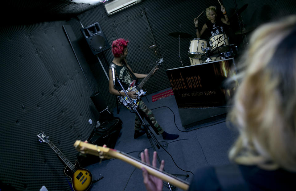 In this Tuesday, July 9, 2013 photo, Kyaw Kyaw, left, and members of punk rock band Rebel Riot rehearse in a Yangon studio, Myanmar. Punk rockers draw double-takes as they dart through traffic, but it's not the pink hair, leather jackets, or skull tattoos that make these 20-somethings rebels: It's their willingness to speak out against Buddhist monks instigating violence against Muslims while others in Myanmar are silent. (AP Photo/Gemunu Amarasinghe)