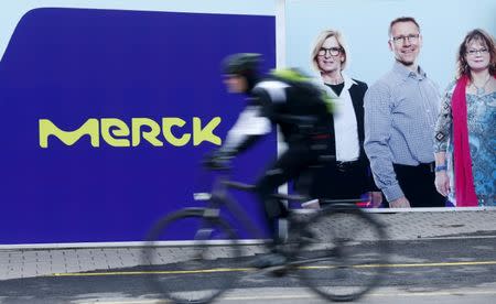 FILE PHOTO: A cyclist rides past a logo of drugs and chemicals group Merck KGaA in Darmstadt, Germany, January 28, 2016. REUTERS/Ralph Orlowski/File Photo