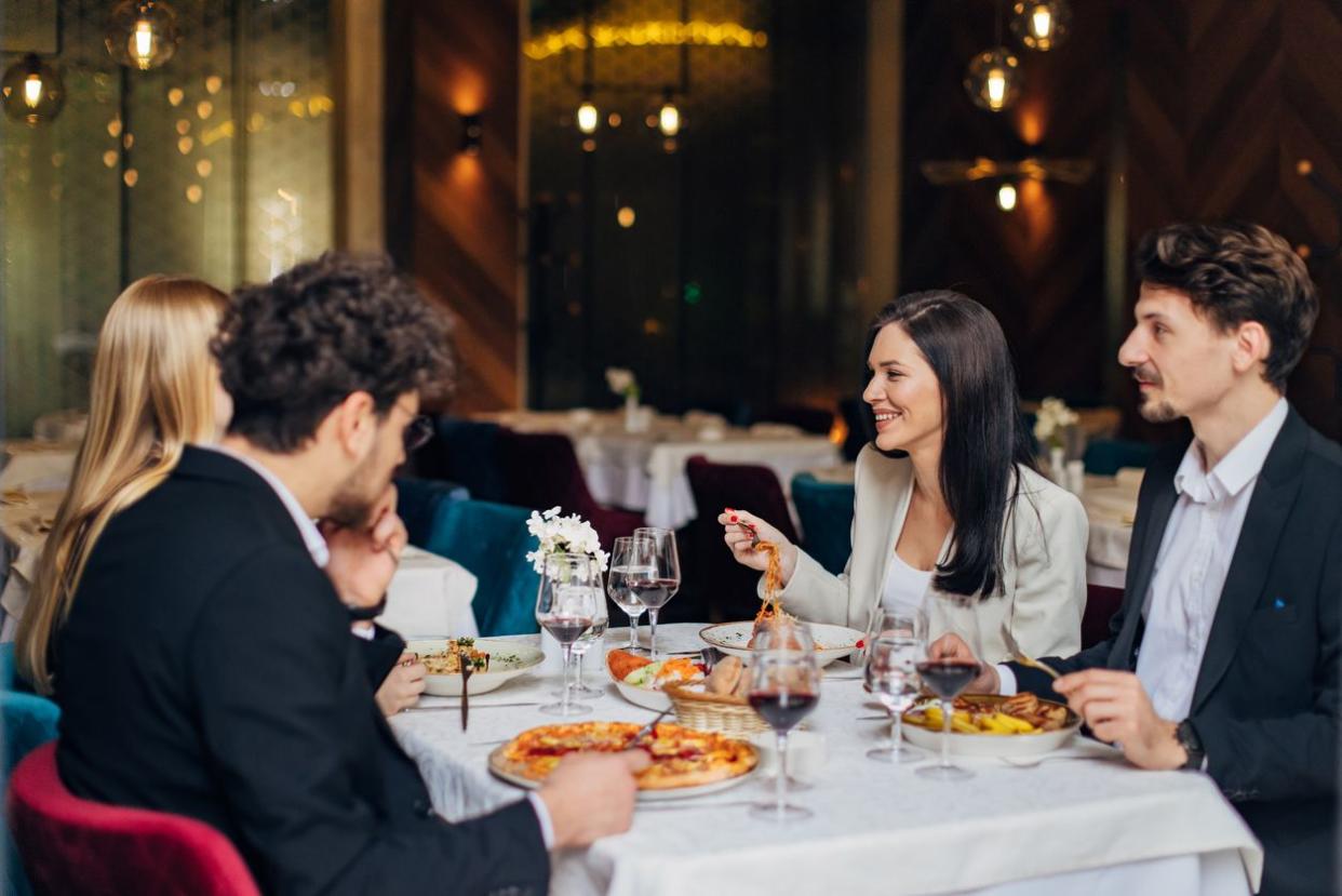 A group of young wealthy people eating pizza together.