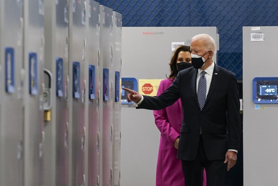 President Biden and Michigan Gov. Gretchen Whitmer walk past freezers that hold Pfizer-BioNtech COVID-19 vaccine.