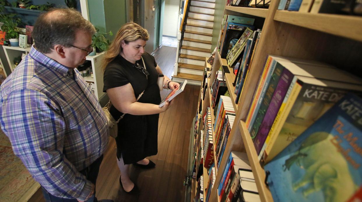 Mary Imparato and Tim Boda look over the collection of books for sale at the Belmont Bookshop Saturday afternoon, April 13, 2024.