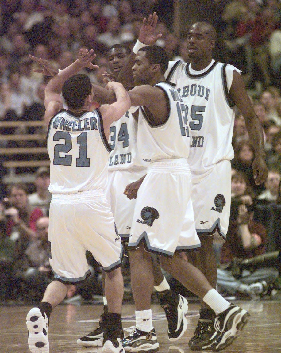 URI players Tyson Wheeler (21), Antonio Reynolds-Dean (34), Cuttino Mobley, and Luther Clay (35) celebrate during a game on March 20,1998.