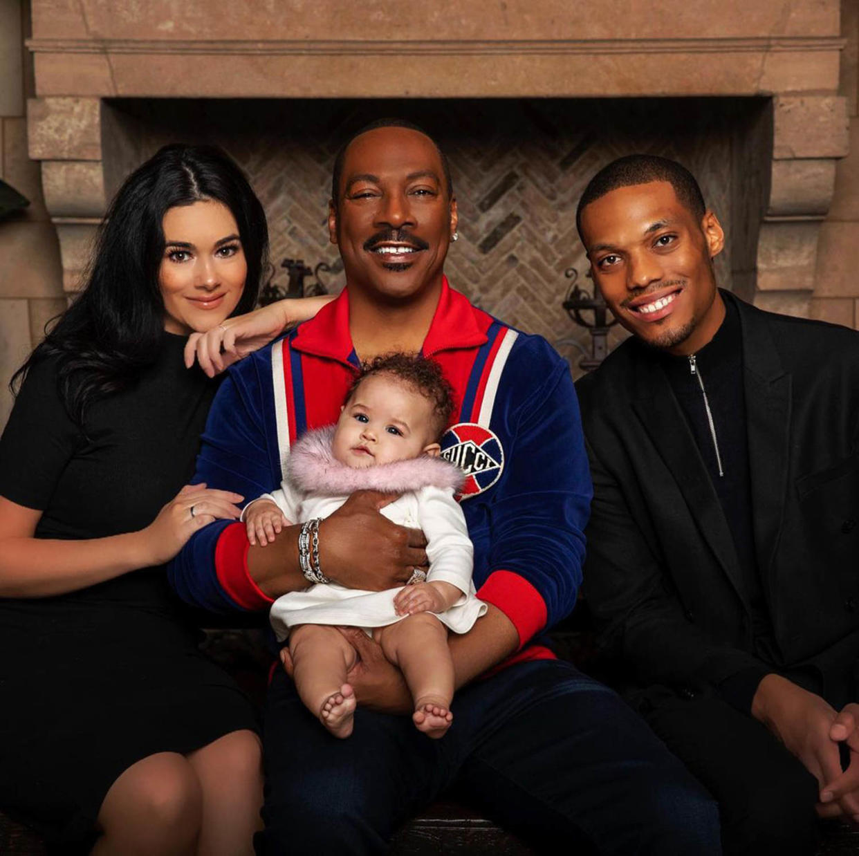 Myles and Carly Murphy pose with Eddie Murphy and their daughter, Evie. (Carly Murphy / Instagram)