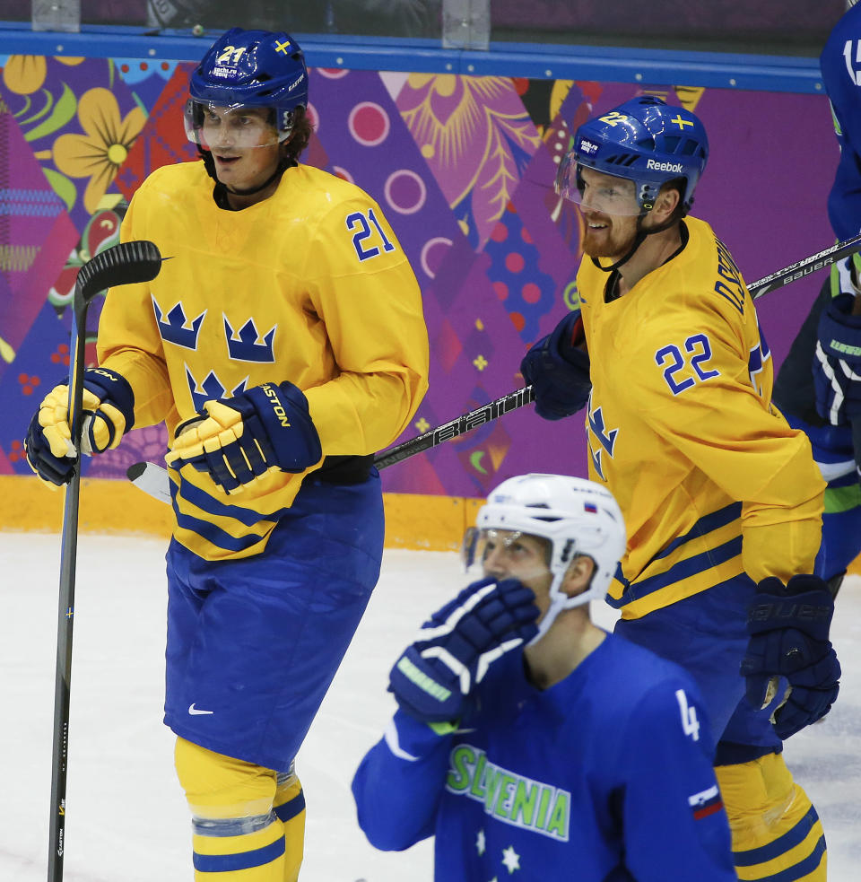 Sweden forward Loui Eriksson and forward Daniel Sedin react after a third period goal by Eriksson against Slovenia during a men's quarterfinal ice hockey game at the 2014 Winter Olympics, Wednesday, Feb. 19, 2014, in Sochi, Russia. (AP Photo/Mark Humphrey)