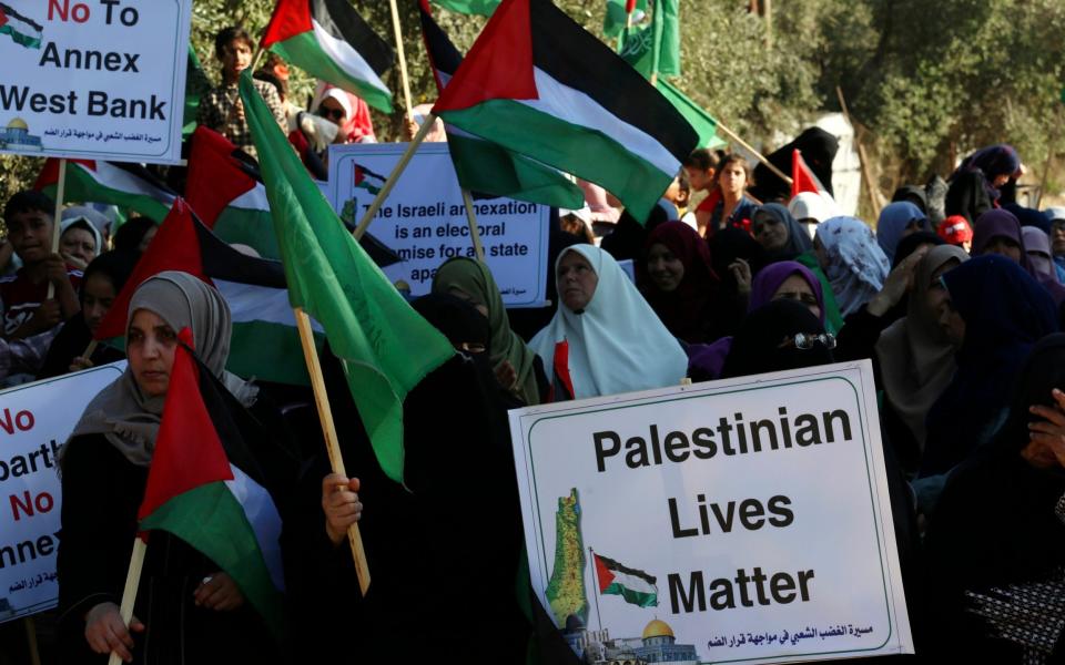 Hamas supporters wave their green and national flags during a protest against Israel's plan to annex parts of the West Bank at the Palestinian side of Erez checkpoint between Israel and Gaza - Adel Hana/Adel Hana