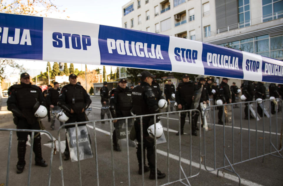 Police officers guard the parliament building in Podgorica, Montenegro, Thursday, Dec. 26, 2019, during a protest against a proposed law regarding religious communities and property. The Serbian Orthodox Church says the law will strip it of its property, including medieval monasteries and churches. The government has denied that. (AP Photo/Risto Bozovic)