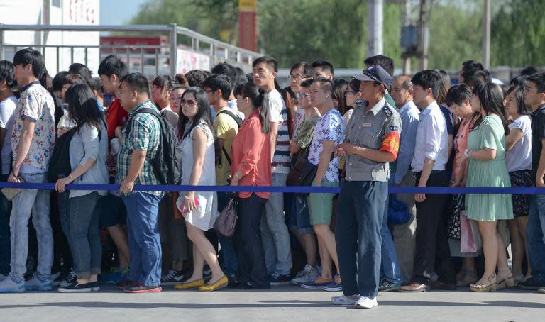 People queue outside a subway station in Beijing on May 26, 2014 to go through a security check