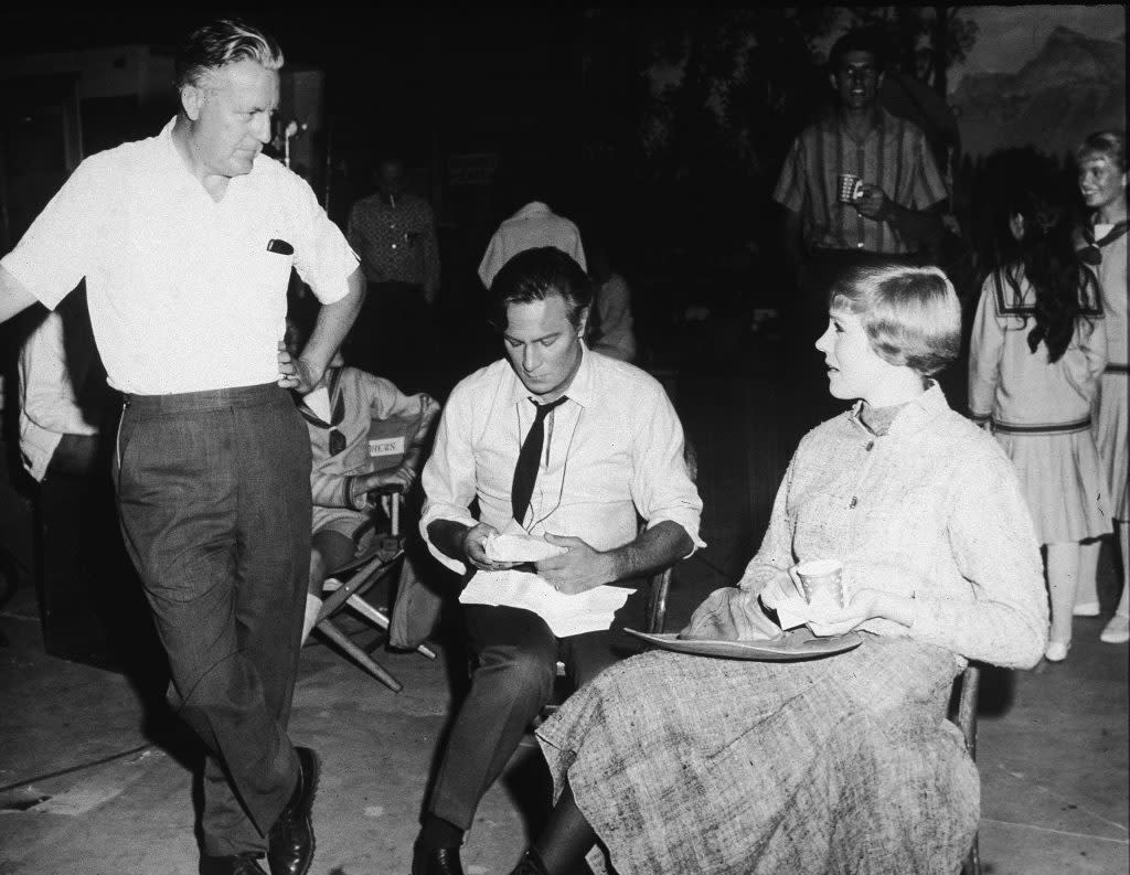 Robert Wise (standing), Christopher Plummer, and Julie Andrews talk during a lunch break on the set of The Sound of Music in 1965. (Photo by Hulton Archive/Getty Images)