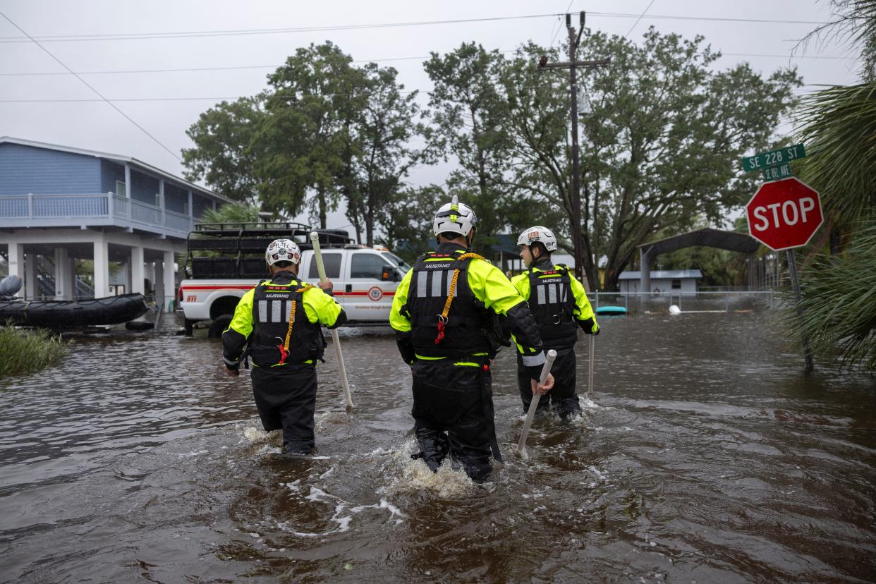 Miami Search and Rescue Fire Department personnel search for people in flooded houses (Reuters)