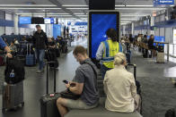 An IT field services technician works on software on an information display during a global technology outage near United Airlines gates at Chicago O'Hare International Airport, in Chicago, Friday, July 19, 2024. (AP Photo/Carolyn Kaster)