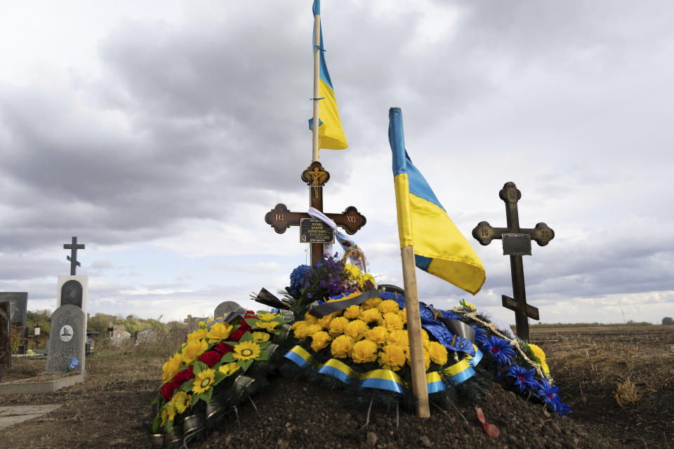 The grave of Ukrainian soldier Andrii Kozyr, who was reburied the day before, in the village of Hroza near Kharkiv, Ukraine, Friday, Oct. 6, 2023. The Russian rocket hit a cafe where friends and relatives gathered for the wake for Kozyr, killing at least 51 civilians in one of the deadliest attacks in recent months. (AP Photo/Alex Babenko)