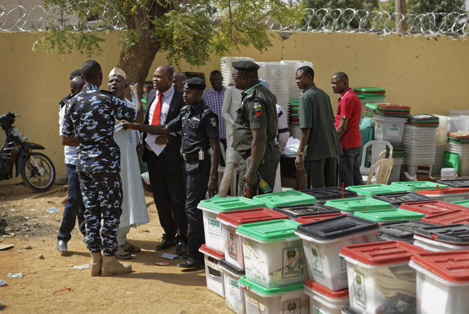 Police attempt to calm opposition supporters who entered a vote compilation center to allege irregularities, before being ejected, in Kano, in northern Nigeria Sunday, Feb. 24, 2019. Vote counting continued Sunday as Nigerians awaited the outcome of a presidential poll seen as a tight race between the president and a former vice president. (AP Photo/Ben Curtis)