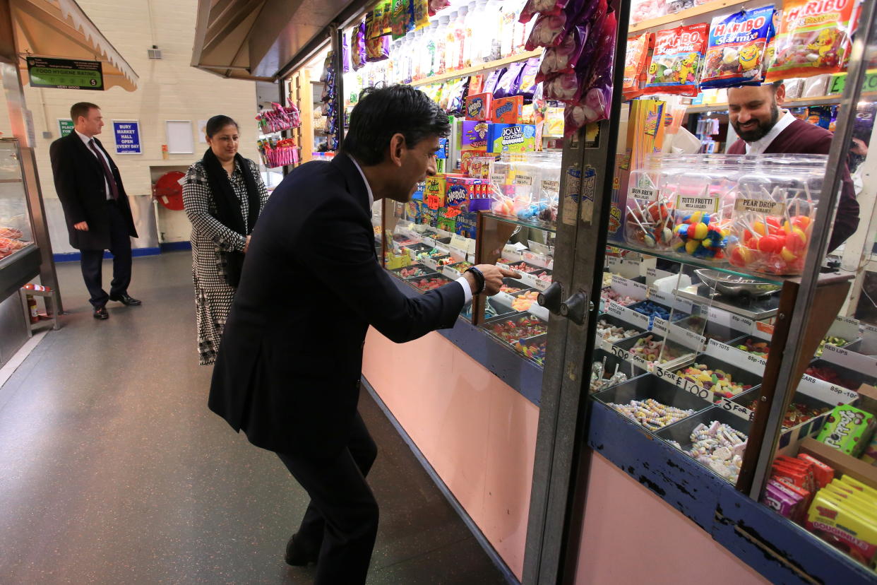 Britain's Chancellor of the Exchequer Rishi Sunak stops at a sweets' stand at the Bury Market in Lancashire, Britain October 28, 2021. Britain's pandemic-hit economy is set to extend its solid recovery into next year despite strong inflationary pressures, Sunak announced in his budget speech. Lindsey Parnaby/Pool via REUTERS