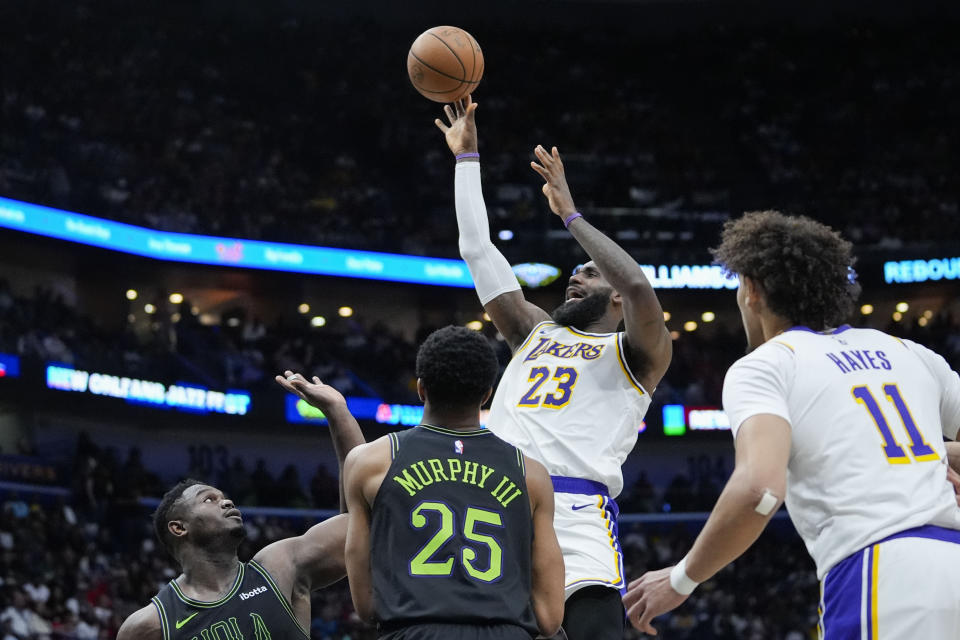 Los Angeles Lakers forward LeBron James (23) shoots over New Orleans Pelicans guard Trey Murphy III (25) and forward Zion Williamson in the first half of an NBA basketball game in New Orleans, Sunday, April 14, 2024. (AP Photo/Gerald Herbert)
