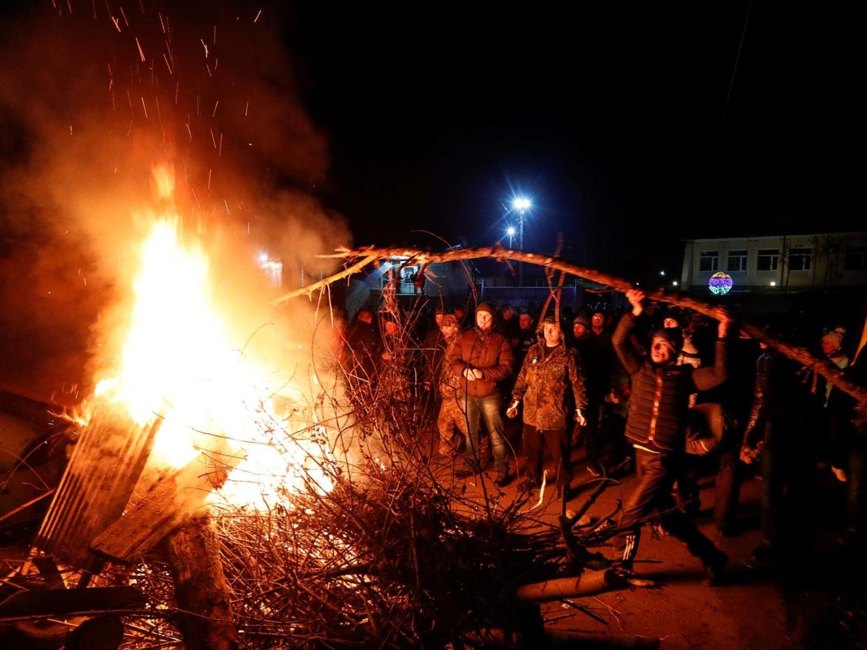 Demonstrators set fire and erect a barricade as they protest the arrival of a plane carrying evacuees from China: REUTERS