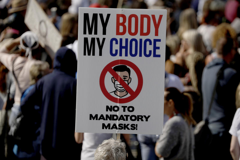 FILE - In this Sept. 19, 2020, file photo, a protester holds up a placard as they take part in a "Resist and Act for Freedom" protest against a mandatory coronavirus vaccine, wearing masks, social distancing and a second lockdown, in Trafalgar Square, London. Psychology experts offer several suggestions for talking to friends and family who believe conspiracy theories about COVID-19. Instead of lecturing or mocking, listen and ask them why they believe what they believe. (AP Photo/Matt Dunham)