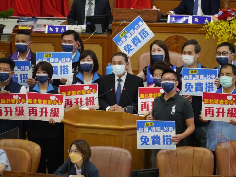 ▲新北市議會國民黨團數位議員手拿「再升級」跟「免費搭」的擴大敬老卡使用議題看板，與侯友宜共同合照。（圖 ／記者吳嘉億攝，2022.9.21）