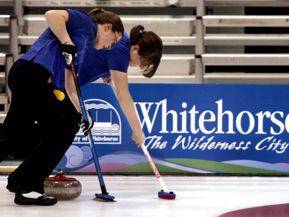 A couple of B.C. curlers work their team's rock down the ice at the 2007 Canada Winter Games in Whitehorse. The city had hoped to again host the event in 2027 but the bid has been withdrawn. (Chuck Stoody/The Canadian Press - image credit)