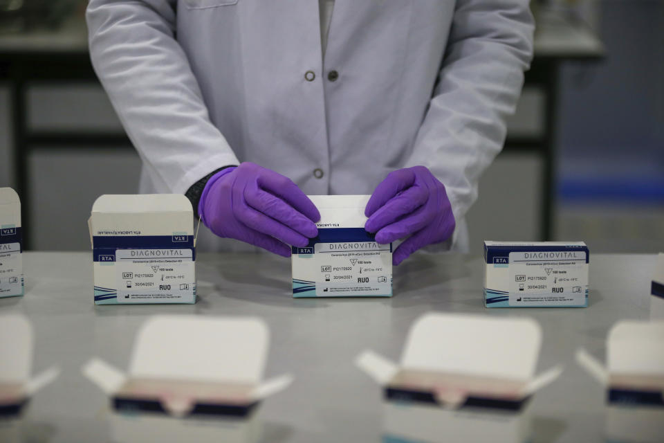 Wearing protective equipment a research and development company worker works on the production of coronavirus testing kits in Gebze, northwestern Turkey, Monday, March 23, 2020. RTA laboratories are now producing 500,000 kits per week for export and their tests are being used in 11 countries across Europe, Middle East and Asia. The test takes up to three hours to return results that have "a sensitivity precision of 99.5%," according to the lab's director. For most people, the new coronavirus causes only mild or moderate symptoms, such as fever or coughing. But for some older adults and people with existing health problems, it can cause more severe illness, including pneumonia. (AP Photo/Emrah Gurel)