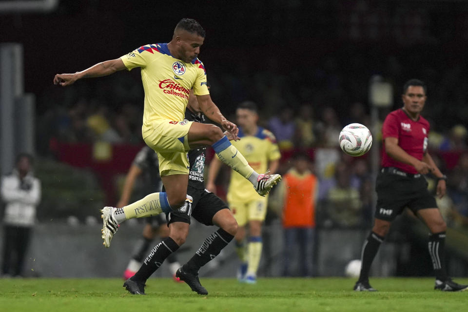 Jonathan Dos Santos (primer plano) del América patea el balón ante Omar Fernández del León en los cuartos de final de la Liga MX, el sábado 2 de diciembre de 2023, en el estadio Azteca de la Ciudad de México. (AP Foto/Marco Ugarte)