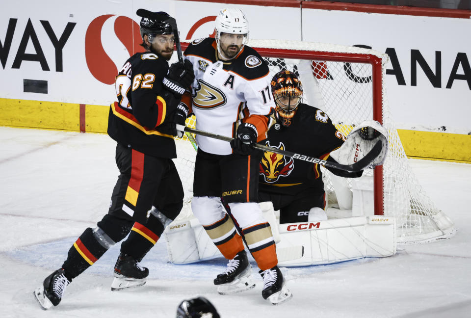 Anaheim Ducks forward Alex Killorn (17) jostles for position with Calgary Flames defenseman Daniil Miromanov (62) as goalie Jacob Markstrom (25) looks for the puck during the first period of an NHL hockey game Tuesday, April 2, 2024, in Calgary, Alberta. (Jeff McIntosh/The Canadian Press via AP)