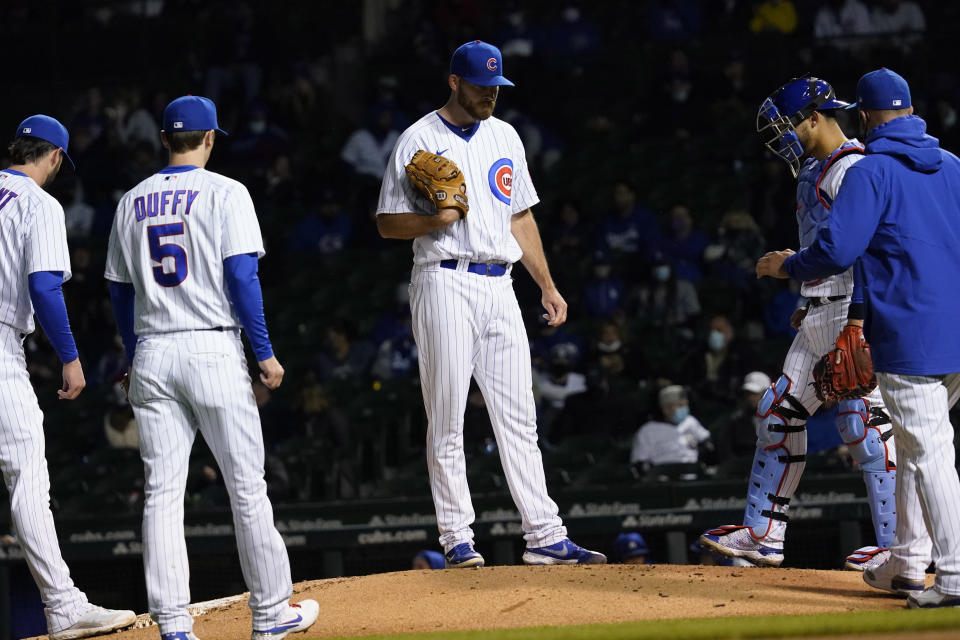 Chicago Cubs relief pitcher Kyle Ryan, center, reacts as he waits for manager David Ross, right, during the sixth inning of a baseball game against the Los Angeles Dodgers in Chicago, Wednesday, May 5, 2021. (AP Photo/Nam Y. Huh)