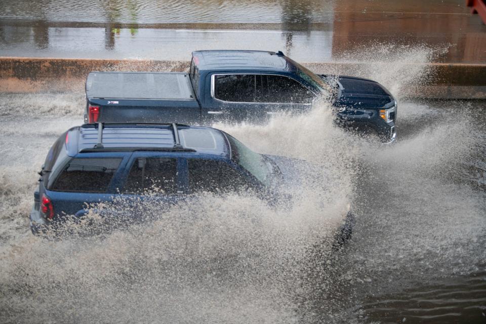 Vehicles drive through a flooded area on Santa Fe Avenue in Pueblo after heavy rain moved through the area on Tuesday, April 25, 2023.