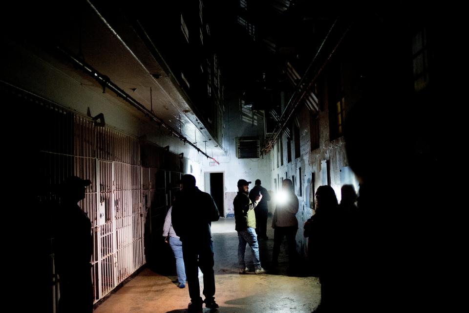 Visitors gather in one of the large cell blocks during a paranormal flashlight tour of Brushy Mountain State Penitentiary in Petros, Tennessee.