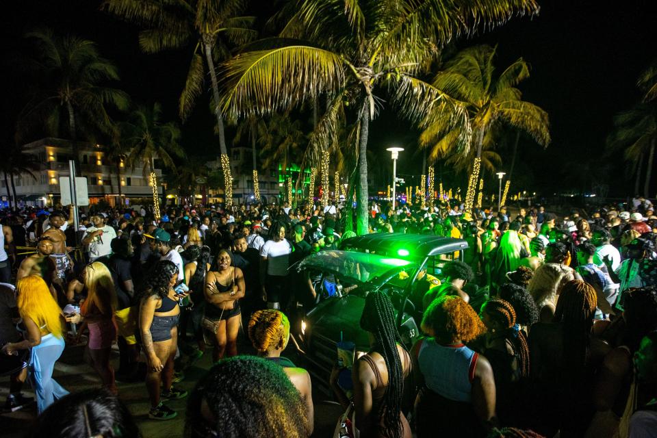 A Miami Beach Police vehicle cuts through crowds near Ocean Drive during Spring Break in Miami Beach, Fla., on Saturday.