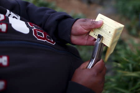 An employee makes perforations on a piece of paper as they count pickers' work at a farm in San Quintin in Baja California state, Mexico April 1, 2015. REUTERS/Edgard Garrido