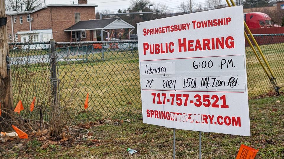 A sign along side The Modernaire Hotel announces a public hearing concerning the Mount Zion Commons development project that would include a mixed-use development.