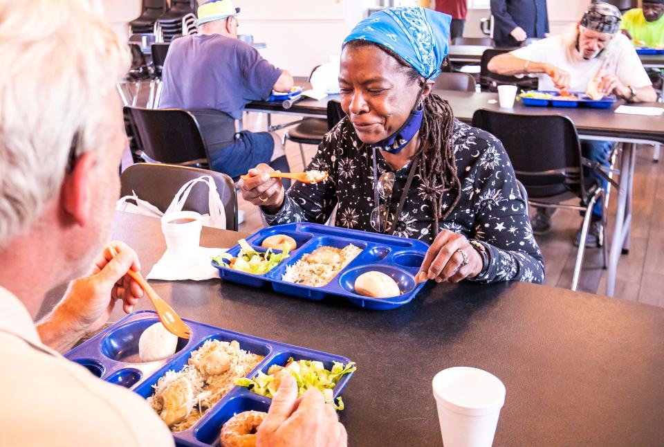 Latonia Baker, center right, enjoys her dinner on May 11 at the Salvation Army Center of Hope's dining hall.