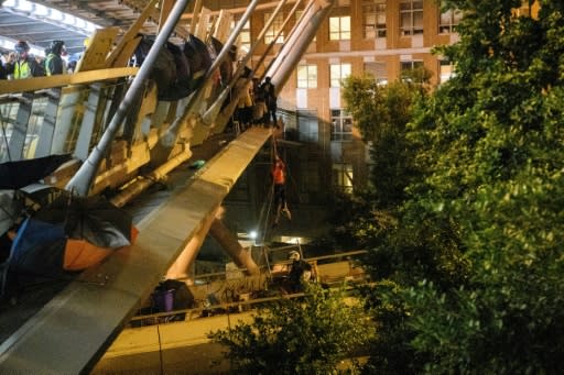 Dozens of people shinned down ropes from a footbridge in a bid to get away from the campus