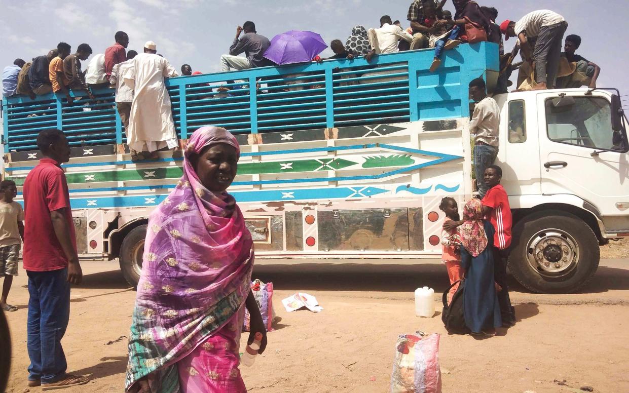 People board a truck as they leave Khartoum, Sudan