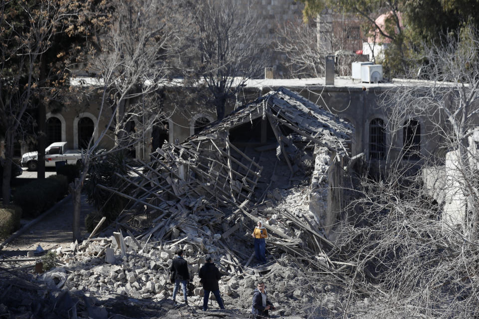 Journalists report from the damage of a medieval citadel after an early morning Israeli airstrike in the capital city of Damascus, Syria, Sunday, Feb. 19, 2023. Syrian state news reported that Israeli airstrikes have targeted a residential neighborhood in central Damascus. (AP Photo/Omar Sanadiki)