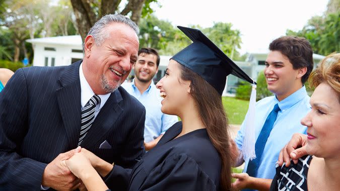 Hispanic Student And Family Celebrating Graduation Smiling.