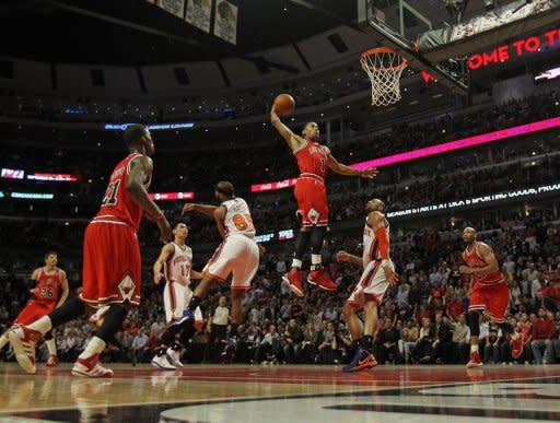 Derrick Rose of the Chicago Bulls goes up for a dunk between Baron Davis and Tyson Chandler of the New York Knicks on his way to a game-high 32 points at the United Center on March 12, 2012 in Chicago, Illinois. The Bulls defeated the Knicks 104-99