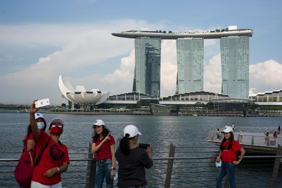 SINGAPORE - 2020/08/09: People wearing face masks as a preventive measure are seen at the Merlion park, one of the major tourist attraction in Singapore and near the Marina Bay Sands during the Singapore National Day. Singapore celebrates its 55th National Day on the 9th of August 2020 amid the Covid-19 pandemic. (Photo by Maverick Asio/SOPA Images/LightRocket via Getty Images)