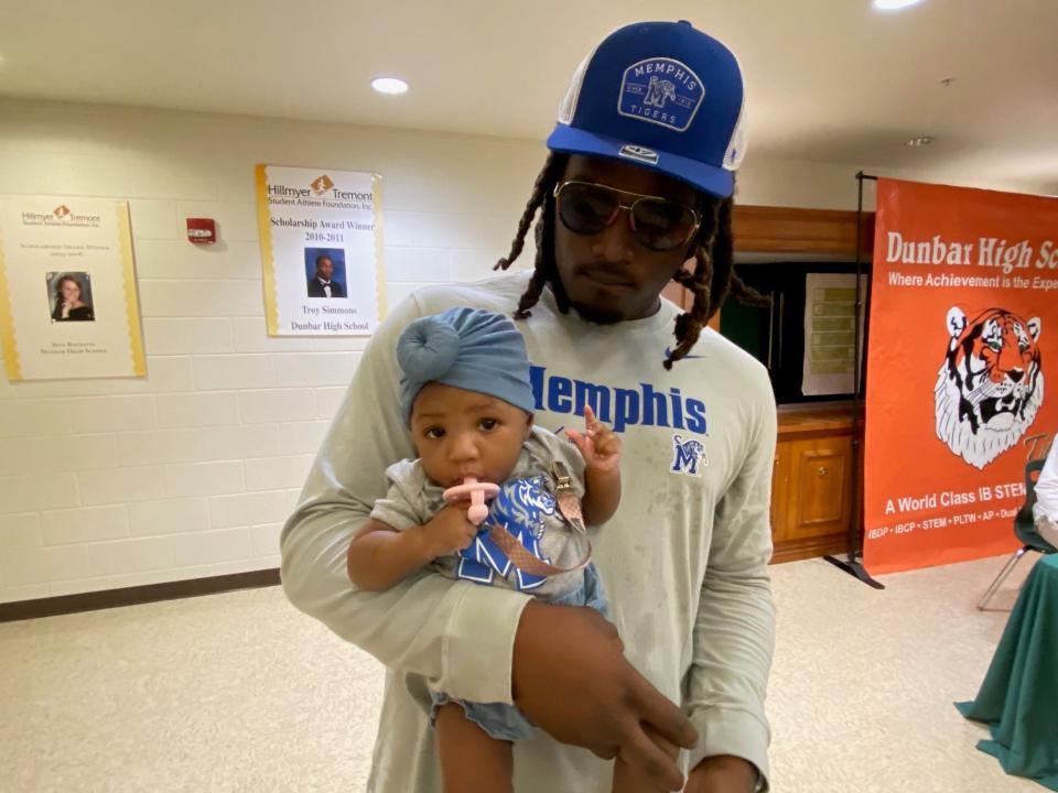 Dunbar High graduate Derick Hunter returned to his alma mater for a signing ceremony where he chose to continue his college career at Memphis on Wednesday, Dec. 21, 2022. He's holding 5-month-old daughter Ava.