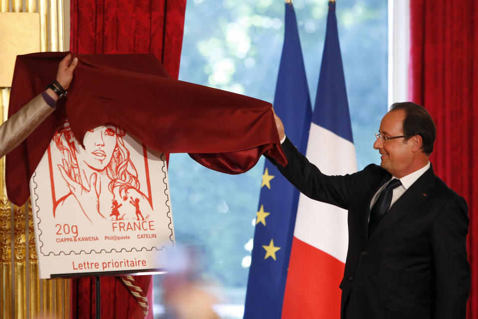 FILE - In this Sunday, July 14, 2013 file photo French President Francois Hollande unveils the new official Marianne postage stamp at the Elysee Palace during the Bastille Day celebrations in Paris. The new face of France _ or at least the official postage stamp for the President Francois Hollande era _ is modeled after a Ukrainian woman who takes her top off to defend feminist causes. Not everyone thinks that’s appropriate. The small, conservative Christian Democrat Party is calling for a boycott of the stamp. Hollande on Sunday unveiled the new stamp, meant to represent Marianne, a symbol of France since the revolution. Afterward, the artist said the image was modeled largely after Femen activist Inna Shevchenko. (AP Photo/Francois Mori, File)