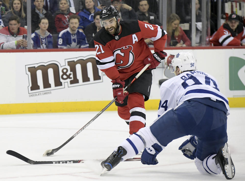 New Jersey Devils right wing Kyle Palmieri (21) shoots as Toronto Maple Leafs defenseman Tyson Barrie (94) defends during the second period of an NHL hockey game Friday, Dec. 27, 2019, in Newark, N.J. (AP Photo/Bill Kostroun)